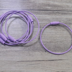 May include: Two purple cable ties, one is coiled and the other is a single loop.