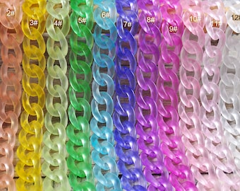May include: Thirteen different colors of plastic chain, each chain is a different color, starting with pink and ending with black. The chains are arranged in a row from left to right.