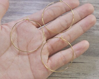 Puede incluir: Tres aros de oro para pendientes de diferentes tamaños. Los aros son de metal fino y tienen un diseño sencillo.
