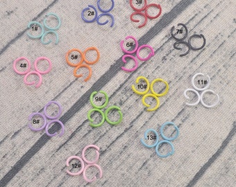 Könnte beinhalten: Sortiment von 13 offenen Ringen in verschiedenen Farben, darunter Pink, Blau, Grün, Gelb, Rot, Schwarz und Weiß. Jeder Ring ist mit einer Nummer von 1 bis 13 gekennzeichnet.