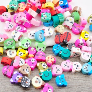 May include: A collection of colourful, cartoon animal-shaped beads. The beads are made of plastic and have a variety of designs, including cats, dogs, bears, and birds. The beads are perfect for making jewellery, keychains, or other crafts.