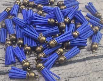Puede incluir: Un conjunto de borlas de gamuza azul con tapas y lazos de color bronce antiguo. Estas borlas decorativas son ideales para la fabricación de joyas, manualidades o para añadir adornos a varios proyectos.