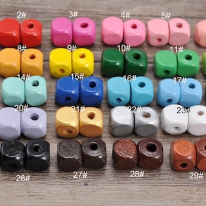 May include: A collection of thirty pairs of small, square wooden beads in various colors, including red, pink, yellow, green, blue, purple, brown, black, white, and natural wood tones, each labeled with a number from 1# to 30#.