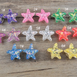 Könnte beinhalten: Zehn glitzernde, farbenfrohe, glitzernde Resin-Seesterne. Jeder Seestern ist von 1 bis 8 nummeriert.