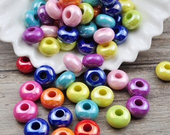 May include: Assortment of colorful iridescent glass beads with a hole in the center. The beads are various shades of blue, green, pink, purple, yellow, and orange.