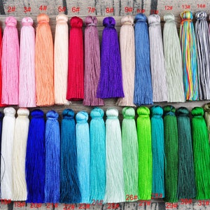 May include: A collection of 33 colorful tassels, each with a different color and number. The tassels are arranged in rows, with the numbers 1 through 33 printed below each tassel.