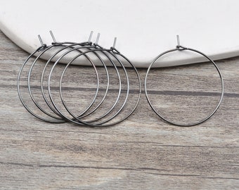 May include: Five black hoop earrings, four are stacked on top of each other and one is separate.