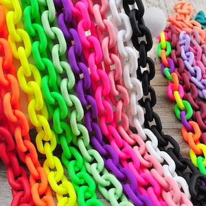 Può includere: Una collezione di catene di plastica colorate in un arcobaleno di tonalità, tra cui rosso, arancione, giallo, verde, viola, rosa, nero e bianco. Le catene sono disposte fianco a fianco, mostrando i colori vivaci e le trame. Ideale per l'artigianato o la decorazione.