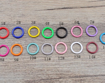 Könnte beinhalten: Sortiment von 15 bunten Metall-Sprühringen in verschiedenen Größen. Die Ringe sind von 1 bis 15 nummeriert.