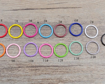 Könnte beinhalten: Sortiment von 15 bunten Metall-Sprühringen in verschiedenen Größen. Die Ringe sind von 1 bis 15 nummeriert.