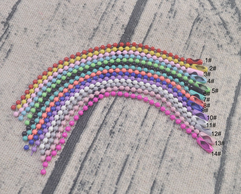 May include: Assortment of 14 colorful metal chains, each with a different color and size. The chains are arranged in a rainbow pattern, with the smallest chain at the top and the largest chain at the bottom.