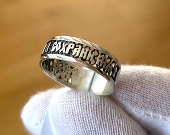 May include: A silver ring with an intricate design featuring a repeating pattern of the Russian word "сохрани" (meaning "save").