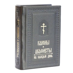 May include: A black leather-bound book with gold lettering. The title is "Kanony i Dkafisty na kazhdyi den".