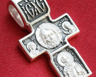 May include: Silver pendant cross with four religious icons, including Jesus Christ, and the inscription "ICXC" on the top.