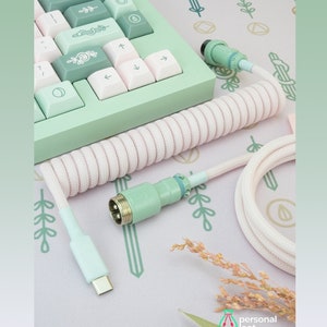 May include: A light green and white keyboard with a coiled white cable. The cable has a green connector on one end and a USB-C connector on the other end. The keyboard has a floral design on the keys. The text "*LISTING IS FOR THE KEYBOARD CABLE ONLY" is visible at the bottom of the image.