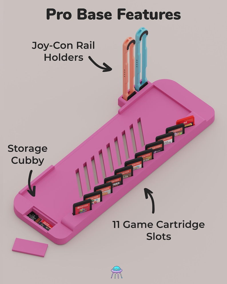May include: A pink gaming console accessory base featuring the text Pro Base Features, Joy-Con Rail Holders, Storage Cubby, and 11 Game Cartridge Slots. It includes two vertical rail holders, a storage area, and eleven slots for game cartridges.