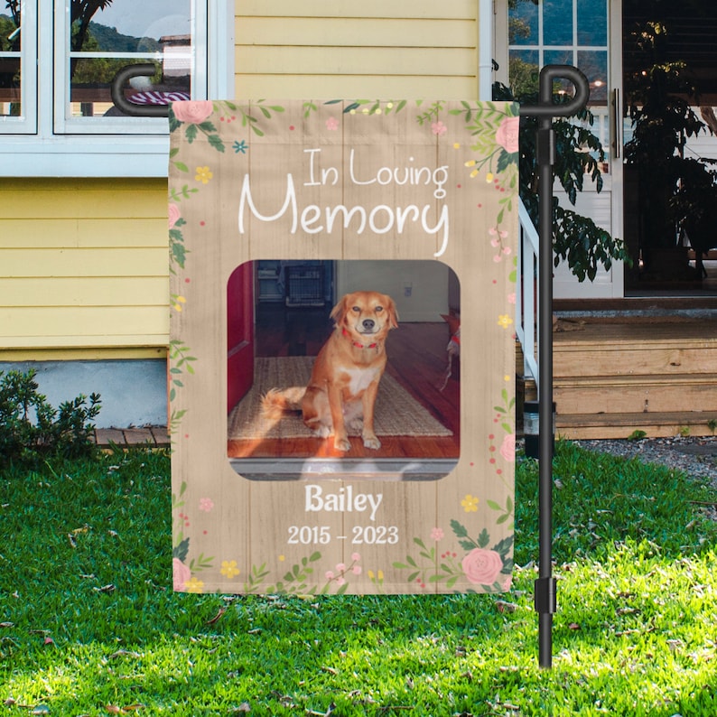 Puede incluir: Una bandera de jard&iacute;n de madera marr&oacute;n con un borde floral y una foto de un perro. La bandera dice "In Loving Memory" y "Bailey 2015-2023".