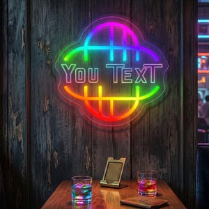 May include: A vibrant neon sign displaying "You Text" in a rainbow gradient, set against a rustic wooden wall. A table below features two glasses with colourful drinks, a phone stand, and a leather wallet.