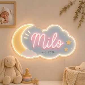 May include: A cloud-shaped LED neon sign featuring a yellow crescent moon, two yellow stars, and the name Milo in pink cursive script. Below the name, the text reads est. 2026 in a simple black font. The sign has a soft blue background.