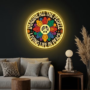 May include: A round, illuminated sign with the text "IMAGINE ALL THE PEOPLE LIVING LIFE IN PEACE" encircling a colorful flower design with a peace symbol at the center. The sign is lit with a warm yellow glow.