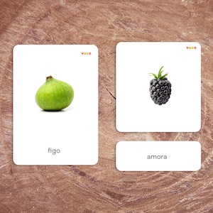 May include: Two white cards with images and text. The left card shows a green fig with the word "figo" below it. The right card shows a black blackberry with the word "amora" below it.