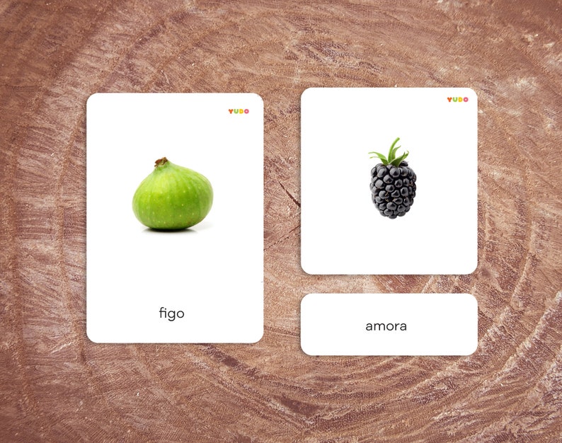 May include: Two white cards with images and text. The left card shows a green fig with the word "figo" below it. The right card shows a black blackberry with the word "amora" below it.