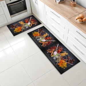 May include: Two black kitchen runner rugs featuring a design of various spices, herbs, and spoons on a dark background.