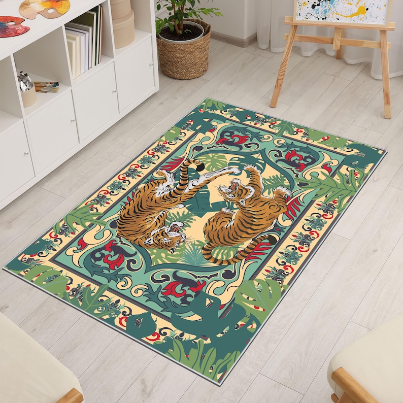 May include: Rectangular area rug featuring a design with two tigers in a playful pose. The rug has a cream-colored background with green, red, and blue decorative elements. The tigers are orange and black.