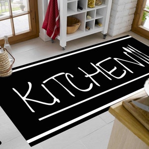 Könnte beinhalten: Schwarz-weißer Küchenvorleger mit dem Wort "KITCHEN" in weiß auf schwarzem Hintergrund. Der Vorleger hat einen weißen Rand.