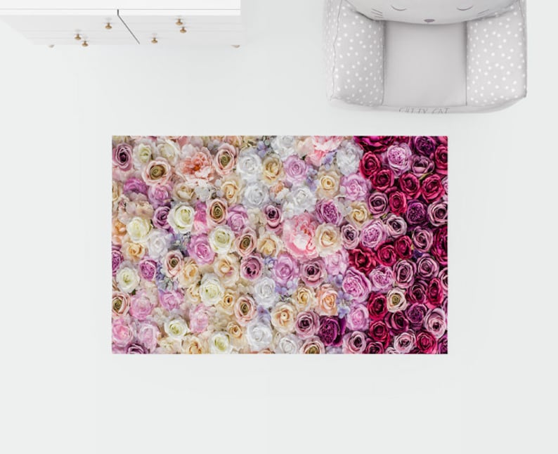 Puede incluir: Una alfombra floral con un esquema de color rosa, blanco y crema. La alfombra est&aacute; hecha de un material suave y mullido y presenta una variedad de flores diferentes.
