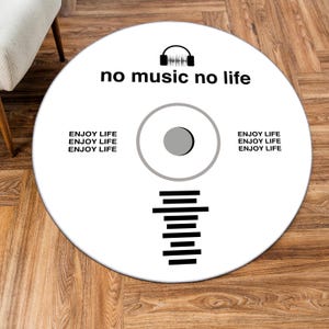 May include: A white, round rug with a black graphic design resembling a CD. The text "no music no life" is above the center. The words "ENJOY LIFE" are repeated around the edge. A headphone icon is above the text.