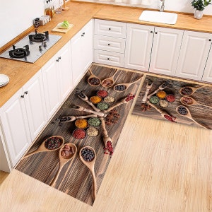 Peut inclure: Tapis de cuisine avec un motif de grain de bois représentant des cuillères en bois remplies de diverses épices. Les tapis sont de forme rectangulaire et sont placés devant un comptoir et un évier de cuisine.