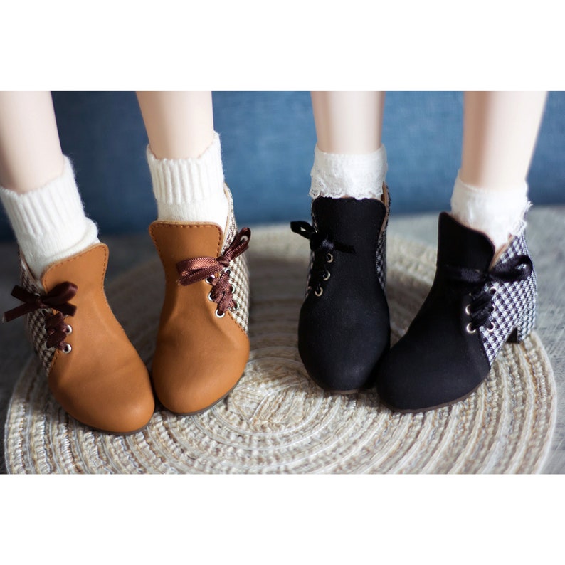 May include: Two pairs of doll shoes with checkered fabric and lace accents. One pair is brown with brown laces and the other pair is black with black laces.