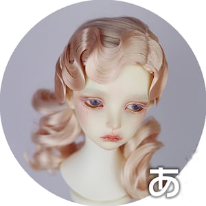 May include: A doll with a light pink wig styled in a vintage updo with loose curls. The wig has a side part and is styled with waves and curls.