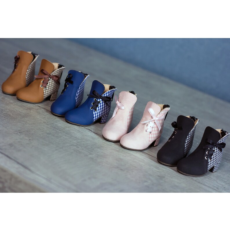 May include: Six pairs of doll-sized boots with gingham fabric accents. The boots are in brown, blue, pink, and black.
