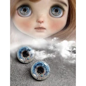 Puede incluir: Un par de ojos de muñeca azules y blancos con una pupila negra y un iris blanco. Los ojos tienen un efecto brillante y brillante.