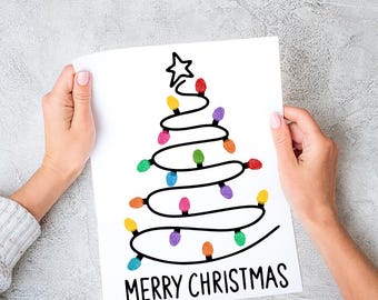 May include: A white sheet of paper with a black outline of a Christmas tree with colorful fingerprint lights and the text "Merry Christmas".
