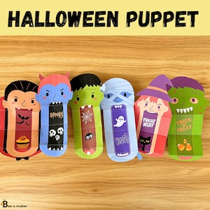 May include: Six Halloween themed paper puppets with different monster faces and sayings. The puppets are on a wooden surface. The sayings include "Spooky", "Boo", "Fright Night", and "Trick or Treat".