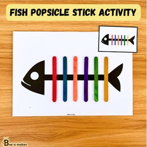Peut inclure: Un modèle d'impression de poisson noir et blanc avec le texte "FISH POPSICLE STICK ACTIVITY" en haut. Le poisson a un cercle blanc pour l'œil. Le poisson est entouré de bâtonnets de sucettes glacées colorés.