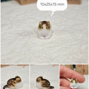 Laying down Brown tabby cat figurine with yellow eyes. If you would like to change the eye color of the Brown with White tabby cat figurine to green, please select the "Eyes/Nose Changes" option.