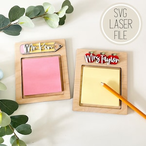 May include: Two wooden notepads with a pencil and apples on top. The notepad on the left says "Mr. Kim" and the notepad on the right says "Mrs. Taylor".