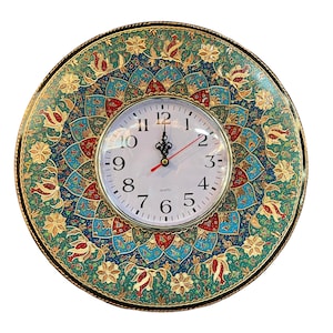 May include: Round wall clock with a decorative face featuring a floral pattern in teal, gold, and red. The clock has a white face with black numerals and hands, and a red second hand. The clock is surrounded by a black border.