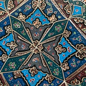 May include: A decorative metal tray with a geometric pattern in shades of blue, green, red, and gold. The tray has a black background and intricate details.