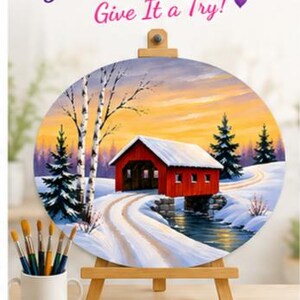 May include: A round canvas on a wooden easel featuring a winter landscape painting of a red covered bridge over a stream, surrounded by snow, birch trees, and pine trees. Text at the top reads: You Can Paint This! Give It a Try!