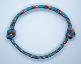 May include: A blue and orange braided rope bracelet with a knot on each end.