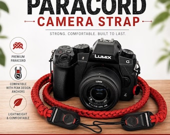 Könnte beinhalten: Eine schwarze Lumix-Kamera mit einem roten Paracord-Kameragurt. Der Gurt ist leicht und bequem, mit schwarzen Anschlüssen. Der Text auf dem Bild lautet "PARACORD CAMERA STRAP" und "STRONG. COMFORTABLE. BUILT TO LAST."