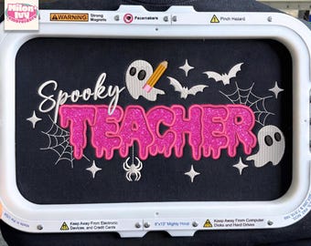 May include: An embroidery design on black fabric inside a white hoop featuring the white text Spooky above the pink glittery text TEACHER. The design includes two white ghosts, a yellow pencil, three bats, a spider, and spider webs.