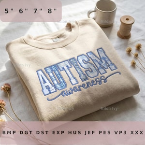 Puede incluir: Sudadera beige con las palabras "AUTISM awareness" bordadas en azul. Las letras tienen un diseño de cuadros. La sudadera mide aproximadamente 13 a 20 cm de ancho.