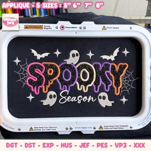 May include: An embroidery design in a white rectangular hoop featuring the text SPOOKY in black glitter with colourful outlines and the word Season in white script. The design includes white ghosts, bats, stars, and spider webs on black fabric.