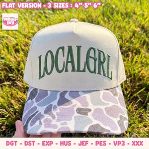 May include: A beige baseball cap featuring the dark green embroidered text LOCALGRL on the front panel. The brim displays a grey and white camouflage pattern. Text at the top indicates flat version 3 sizes: 10.16 cm, 12.7 cm, 15.24 cm.